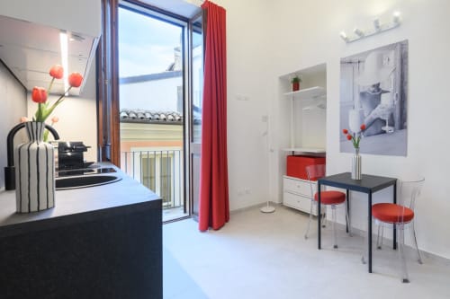 Suite moderna a Sulmona con accenti rossi, vista dal balcone, tavolo da pranzo e arredi contemporanei