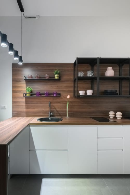 Cucina moderna nelle Suites Tormalina Design dell'Hotel Almatros a Sulmona con rivestimento in legno, mobili bianchi e lavello nero