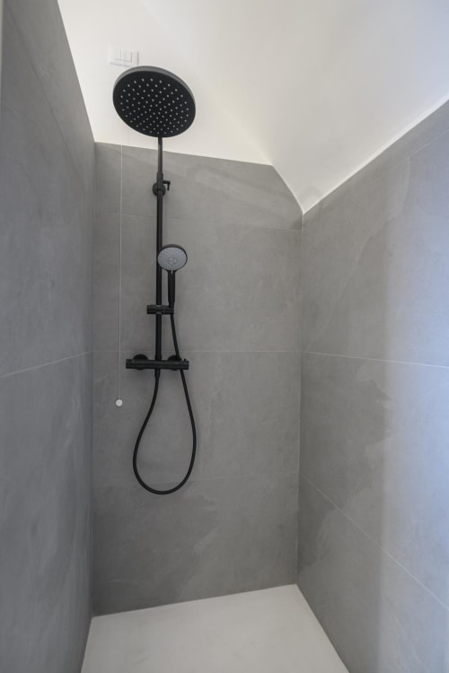 Soffione doccia nero moderno con doccetta manuale nelle Suites Tormalina presso l'hotel Almatros di Sulmona