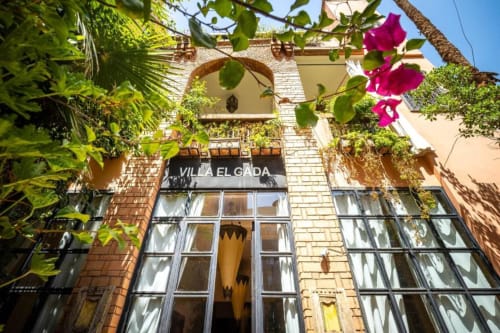 Entrée de la Villa El Gada à Marrakech avec bougainvillées fleuries, portail voûté et architecture traditionnelle