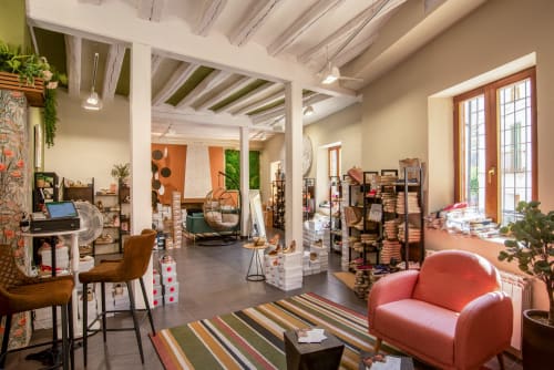 Recepción de hotel boutique en Cervera del Río Alhama con mobiliario moderno, vigas vistas y decoración colorida