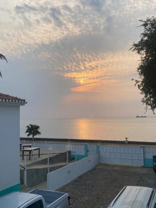 Vista do pôr do sol do terraço à beira-mar do Hotel PZero em Albufeira com céu dourado refletido nas águas tranquilas