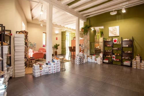 Tienda de regalos del Hotel-Boutique by Gonzalo Sesma con cajas de zapatos blancas, paredes verde oliva y expositores en Cervera del Río
