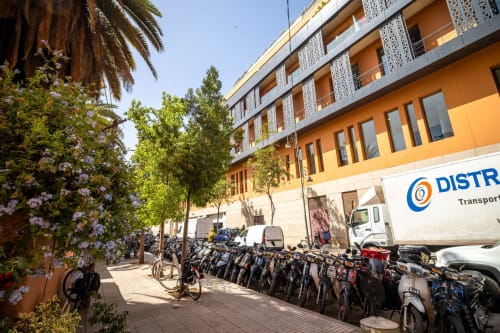Cour de la Villa El Gada à Marrakech avec vélos garés, façade orange et palmiers