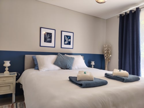 Chambre Pastel du Beauregard BnB avec tête de lit bleu marine, literie blanche et vue sur le jardin à Donneville
