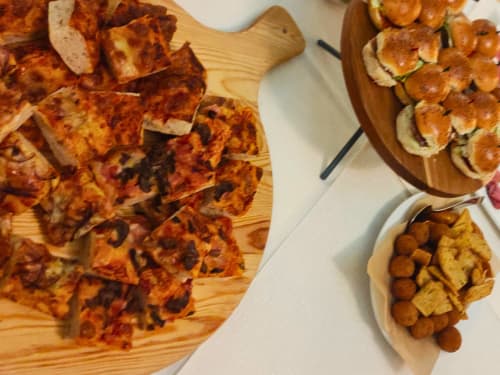Pizza slices and appetizers on wooden boards at Hotel Ristorante alle Querce, Castelbuono