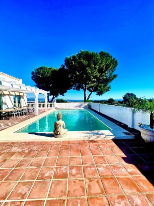 Piscina privada de Villa Magos con vistas al océano, Málaga. Piscina rectangular turquesa, patio de terracota, árbol mediterráneo y