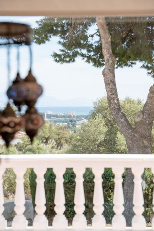 Villa con terraza en Málaga, vistas al océano y la montaña, balaustrada ornamental y árboles mediterráneos