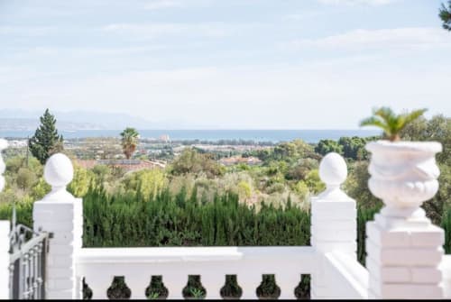 Vista de la terraza de Villa Magos en Málaga con vistas al Mar Mediterráneo, jardines exuberantes y paisaje costero