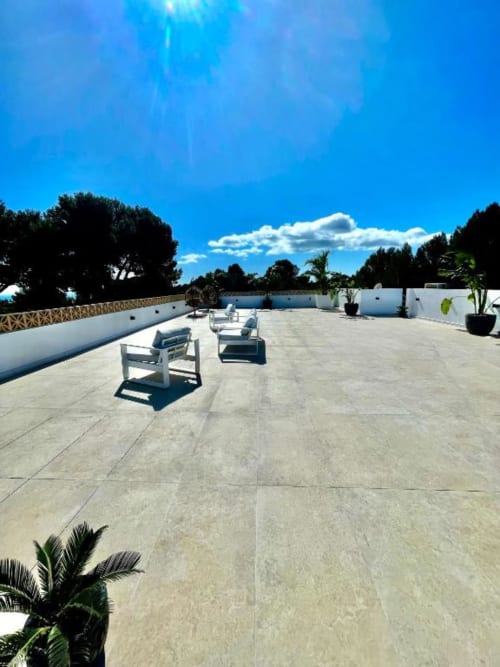 Amplia terraza de Villa Magos en Málaga con tumbonas blancas, vistas al océano y cielo azul despejado