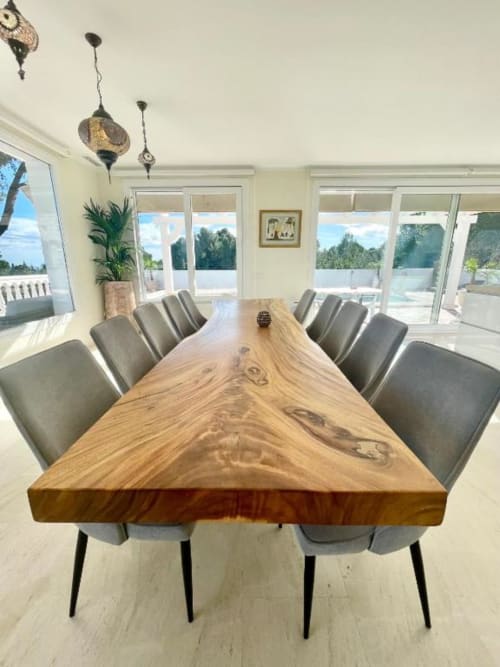 Comedor moderno con mesa de madera, sillas grises y vistas al océano en Villa Magos de Málaga