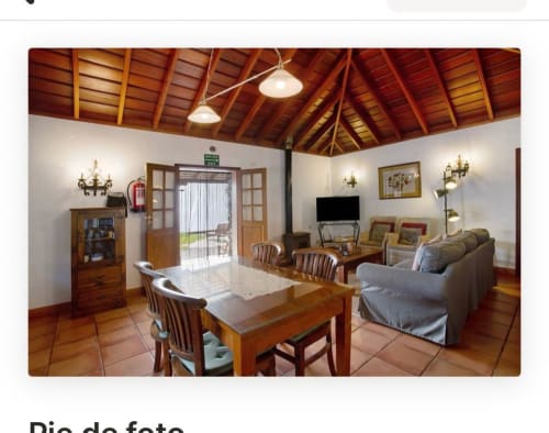 Amplio salón en villa rural con vigas de madera, comedor, zona de estar y vistas a la terraza en el hotel La Palma