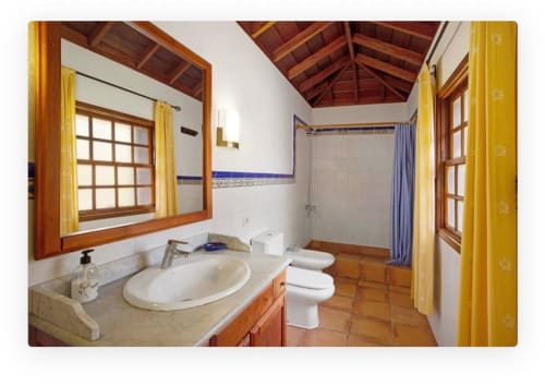 Amplio cuarto de baño en villa Casa Rural Los Llanos Negros, Fuencaliente La Palma, con vigas de madera, doble lavabo y ducha.