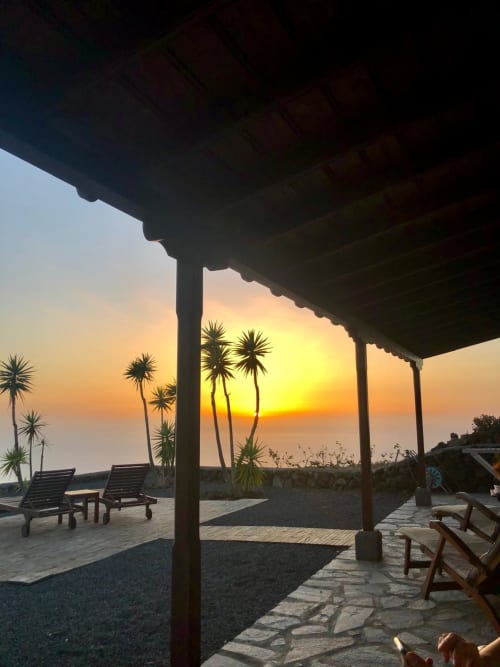 Atardecer desde la terraza de la villa con tumbonas, palmeras y vista al mar en Fuencaliente, La Palma