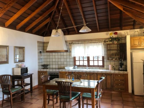 Amplia cocina y comedor de villa con vigas de madera, encimeras de azulejos y vistas al mar en La Palma, Canarias