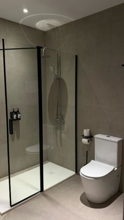 Baño moderno en Hotel ITOUR con ducha a ras de suelo, inodoro y equipamiento contemporáneo en Museros, España