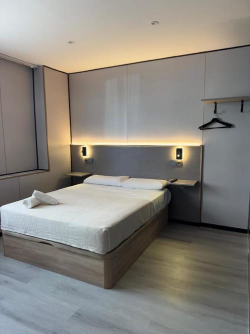 Dormitorio doble moderno en ITOUR Hotel en Museros con diseño minimalista, iluminación ambiental y mobiliario contemporáneo