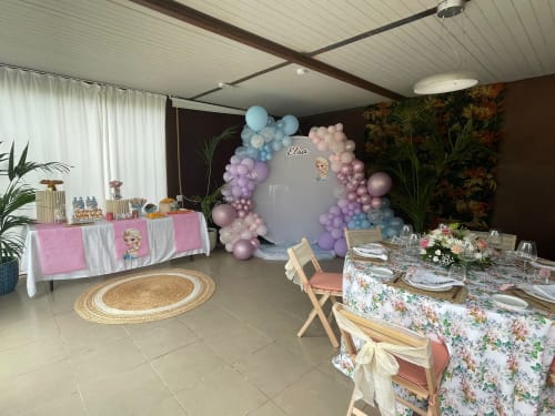 Elegante salón de eventos del Hotel Las Calas con arco de globos pastel, mesas decoradas y arreglos florales