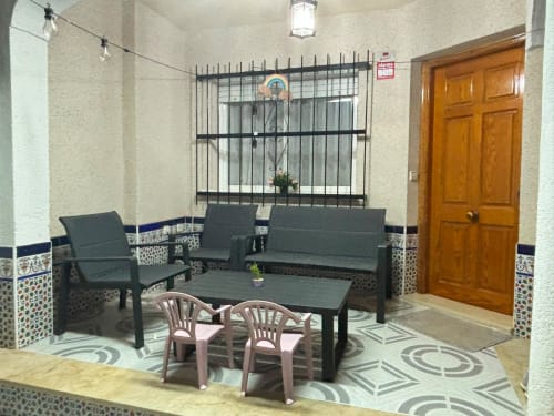 Sala de estar con zona de descanso y ventana con rejas en la casa de vacaciones Haus Holiday Homes en Los Alcázares, a 500m de la playa