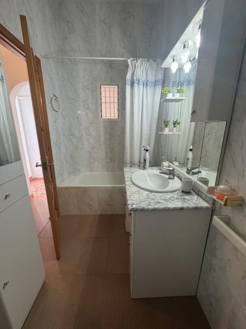 Moderno baño en la casa rural Los Alcázares con tocador de mármol, lavamanos redondo, cabina de ducha e iluminación brillante