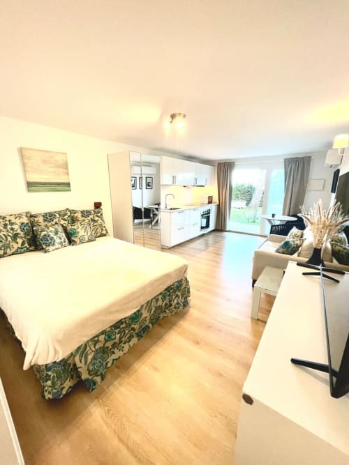 Moderno dormitorio tipo estudio con cocina, sala de estar y acceso al jardín en el hotel boutique Villa Magos de Málaga