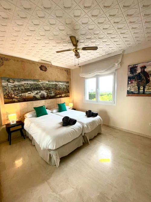 Habitación doble en Villa Magos B&B de Málaga con camas blancas, almohadas verdes, techo texturizado y vistas panorámicas