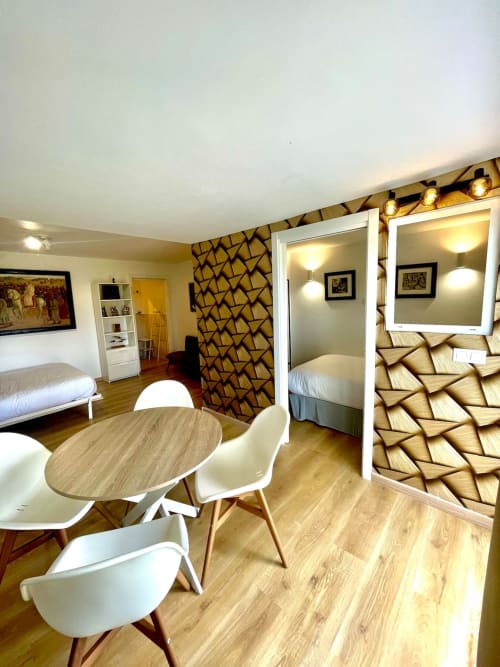 Estudio moderno en Villa Magos B&B de Málaga con sala abierta, comedor y dormitorio con decoración geométrica en la pared