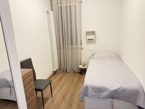Accogliente camera da letto dell'appartamento Ohana a Montecchio Maggiore con letto singolo, poltrona e riscaldamento a radiatore