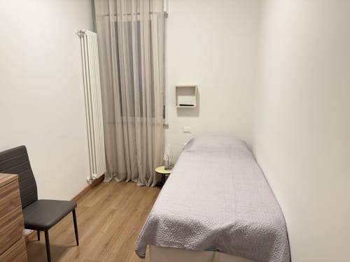 Camera dell'appartamento Ohana a Le case di Clara, Montecchio Maggiore con letto singolo, sedia, radiatore e tende