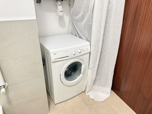 Lavatrice bianca nel bagno dell'appartamento Ohana presso Le case di Clara, Montecchio Maggiore