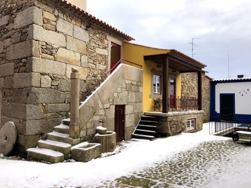 Traditional stone cottage with yellow accents at Quinta das Pias rural guesthouse in Portugal, featuring rustic architecture
