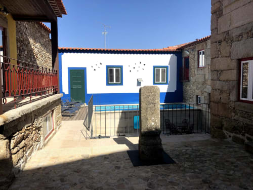 Colorful blue and white Portuguese beach house with stone walls and traditional tile roof at RISOTURISMO