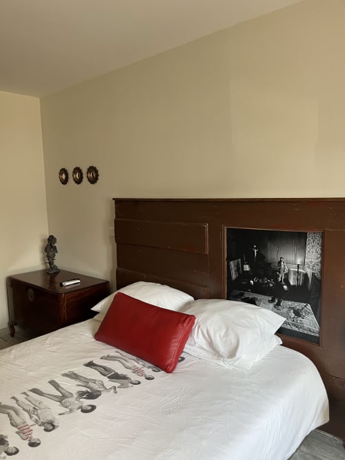 Quarto Wellington bedroom at Quinta das Pias with dark wood bed, red pillow, white linens, and vintage decor