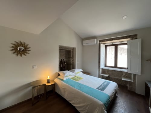 Quarto Junot na RISOTURISMO com cama queen, assoalho de madeira, comodidades modernas e luz natural das janelas