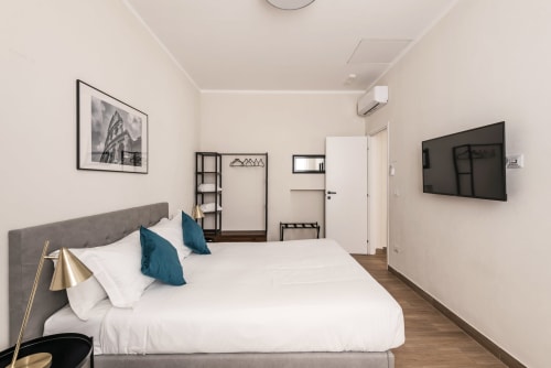 Camera moderna a Flavia's Holiday Home a Roma con letto matrimoniale, TV e arredamento minimalista