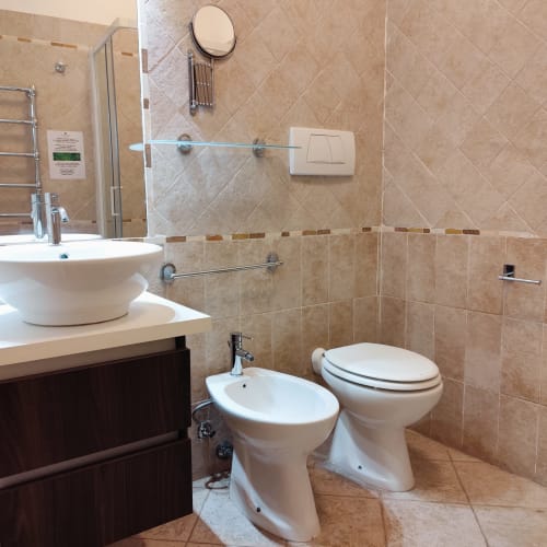 Bagno moderno nella Junior Suite del Green Hotel Poggio Regillo a Frascati, con piastrelle beige, bidet, WC e lavabo vessel