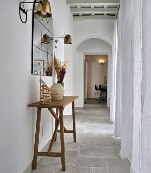 Pasillo moderno con consola de madera, lámparas de latón y flores secas en macetas en el apartamento Casa De La Cruz Vejer