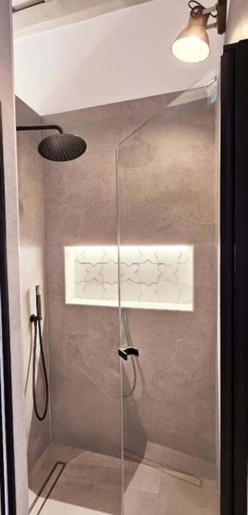 Moderno baño con ducha tipo lluvia, mamparas de cristal y acabados en azulejos blancos en el apartamento Casa De La Cruz Vejer