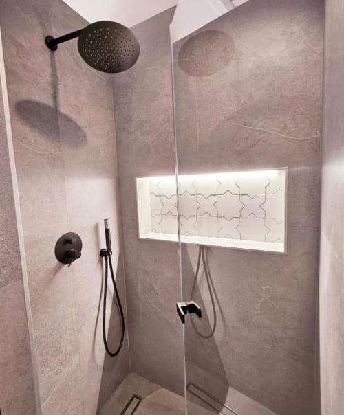 Moderno nicho de ducha con alcachofas de lluvia negra, ducha de mano, hornacina iluminada con azulejos decorativos y