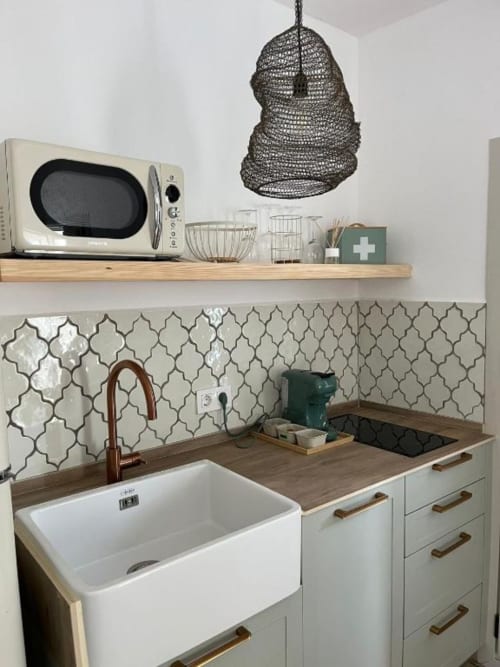 Moderna cocina en Casa De La Cruz Vejer con fregadero de granja blanco, azulejos geométricos, encimeras de madera y