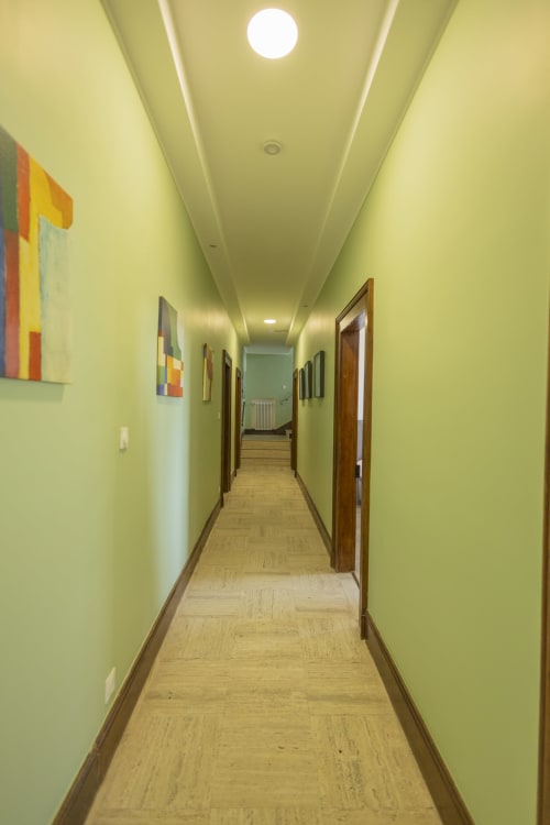 Couloir jaune éclatant de l'hôtel Accolade Villa Chateaudine avec portes en bois et éclairage plafond moderne