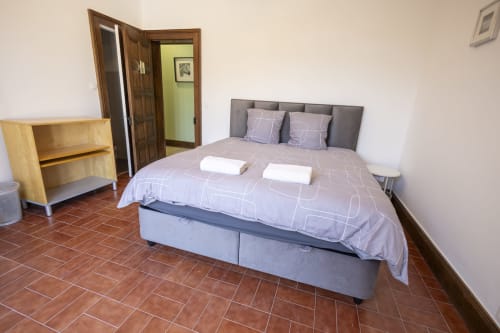 Chambre spacieuse à l'hôtel Villa Chateaudine à Châteaudun avec lit double, commode en bois et sol en terre cuite