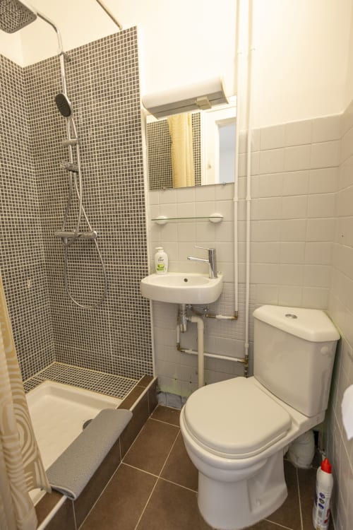 Salle de bain moderne à la Villa Chateaudine avec douche spacieuse, toilettes blanches, lavabo et miroir à l'hôtel Accolade, Châteaudun