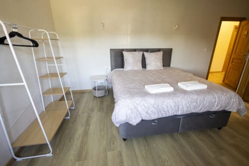 Chambre spacieuse à la villa Accolade Châteaudun avec lit queen-size, étagères blanches et parquet