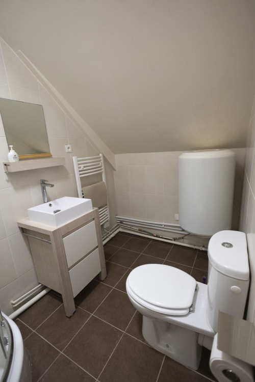 Salle de bains moderne à la Villa Chateaudine d'Accolade Châteaudun avec toilettes, lavabo, sèche-serviettes chauffant et ballon d'eau chaude