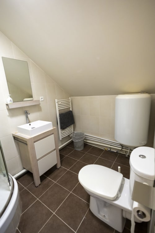 Salle de bain moderne à la Villa Chateaudine de l'hôtel Accolade, Châteaudun, avec toilettes, lavabo, sèche-serviettes chauffant et ballon d'eau chaude