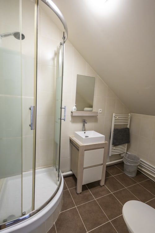 Salle de bain moderne à la Villa Chateaudine, hôtel Accolade, Châteaudun : douche pluie, vasque blanche, chauffée