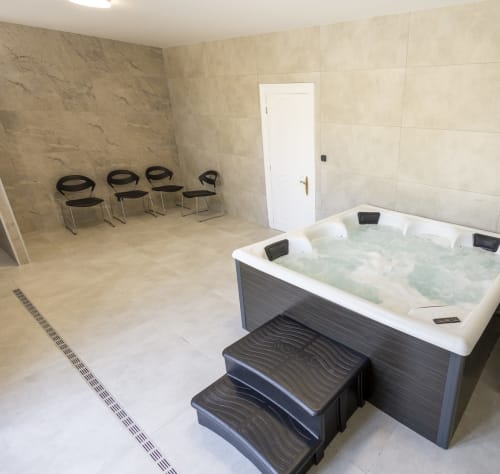 Villa Accolade - Chambre Jacuzzi avec baignoire chauffée, marches d'accès et coin salon à Châteaudun