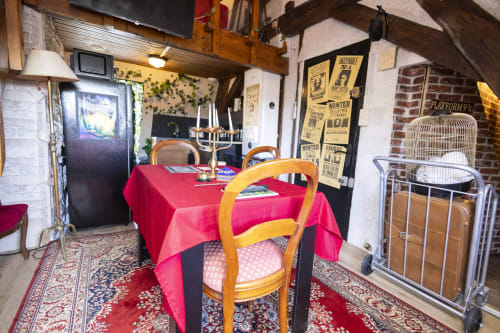 Appartement thématique école de sorciers Harry Potter à l'hôtel Accolade à Châteaudun avec nappe rouge, chaises en bois et avis de recherche