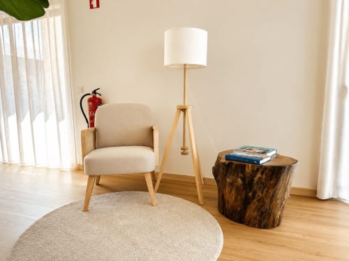 Aconchegante área de estar no Terra Clara Studios com poltrona bege, luminária de tripé e mesa lateral de madeira rústica no apartamento de Esposende